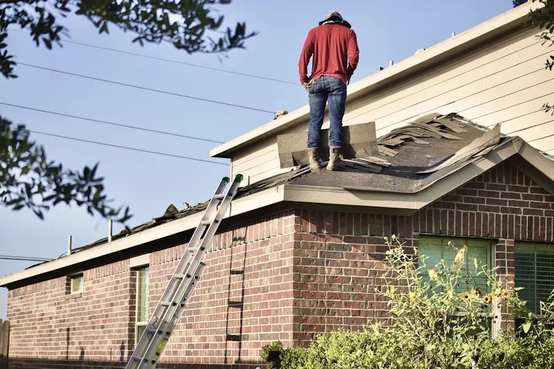 Professional roofer working on a residential roof in Downtown Manchester